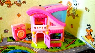 Как ребенок играет в кукольный домик? Ребенок играет в игрушки. Красивый, компактный кукольный домик