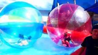 Батман и маленькая девочка играют в шарах в воде