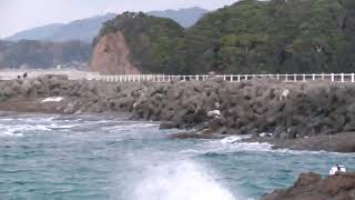 ３連休最終日、荒れている海の中竿を出す釣り人。