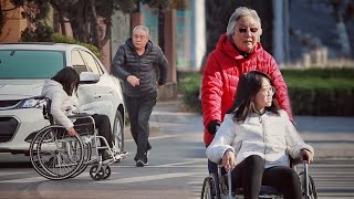 When a girl in a wheelchair crosses the street alone, what will passers-by do? 当乘坐轮椅的姑娘独自过马路......