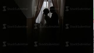 silhouettes of the bride and groom on the window background