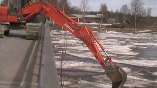 Tulvavideo 2011 Kaivuri Skatilassa.wmv. Kyrönjoki. Excavator on bridge crushing ice.