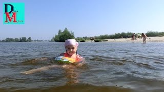 Учимся плавать с детским надувным кругом на пляже