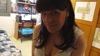 Crossdresser hetero con top escotado, falda larga y pendientes plumas