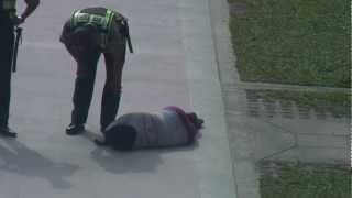 Drunk woman passed out in the street and cops walk away.