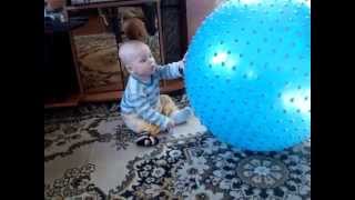 Как ребенок 8 месяцев играет с большим синим мячом
