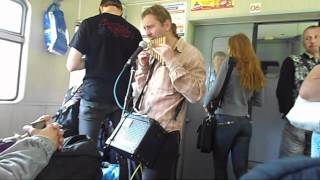 Мужчина играет на сампонье (панфлейте) в электричке