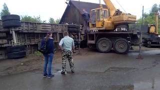 Кран пытается поднять кабину лесовоза, который въехал в дом в Кирове