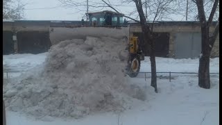 Фронтальный погрузчик  очищает от снега.