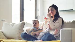 Mother and her son are watching tv while sitting on a couch