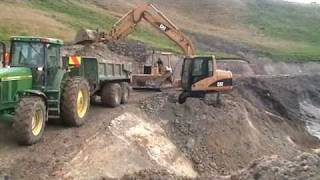 john deere 7810 tractor/trailer being loaded by cat 312c excavator