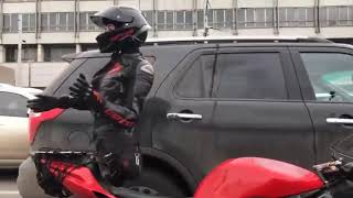 девушка мотоциклистка в пробке танцует