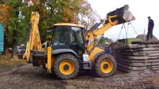 Экскаватор-погрузчик JCB 4 CX укладывает дорожные плиты
