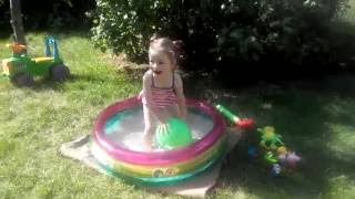 Детский бассейн Яна играет в бассейне лопает шарики с водой