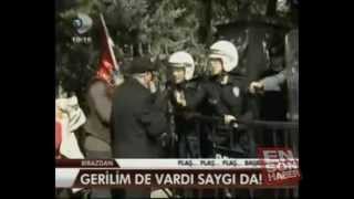 Türk bayragini yerden alip öperek basina koyan Bayan Cevik