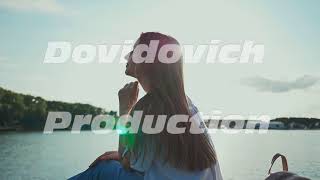 Pretty young girl sitting at the seashore watching the setting sun
