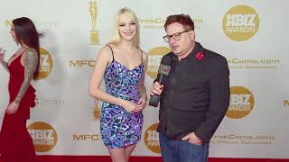 Kenna James in a flattering blue and purple dress on the red carpet at the Xbiz Awards in LA, CA.