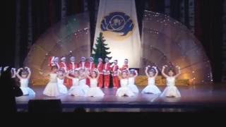 танец Санта Клаусов и снежинок на сцене